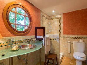 A bathroom with a round window, a glass sink, a mirror, a toilet, and a shower area. - Can Mandol - Spectacular luxury house with pool and large garden (Inca)