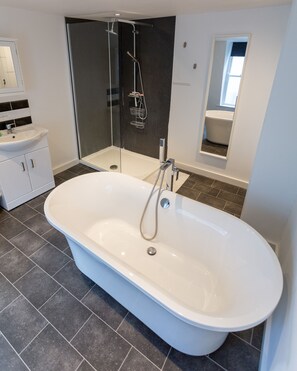 Bathtub, hair dryer, towels, toilet paper