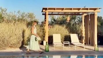 Ein Schwimmbecken mit Liegestühlen und einer Pergola.