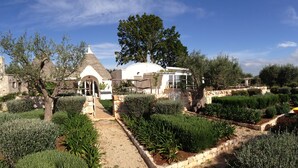 A historic building with a dome and a bell tower, surrounded by well-maintained gardens and pathways. - Il Trullo di Ben (Locorotondo)