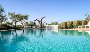 A clear swimming pool with lounge chairs and a tree. - Il Trullo di Ben (Locorotondo)