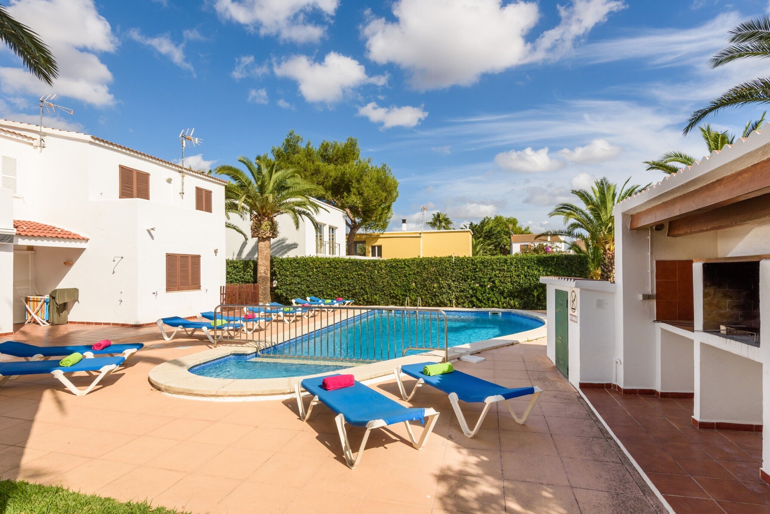 Zona de piscina amb gandules, piscina i zona de barbacoa.