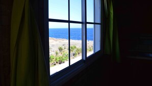 A window with a view of a beach and ocean.