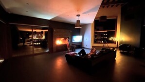 Un salon spacieux avec une cheminée, un téléviseur et un canapé.