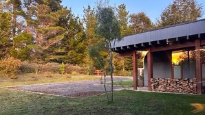 Un bâtiment moderne doté d’un patio couvert, entouré d’un jardin bien entretenu et d’une allée en gravier.