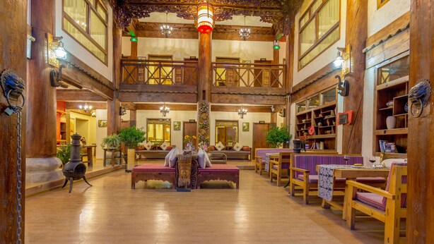 A spacious lobby with wooden floors, a central seating area, and a mezzanine level. - Shangri-La E-Outfitting Boutique Hotel (Deqin)