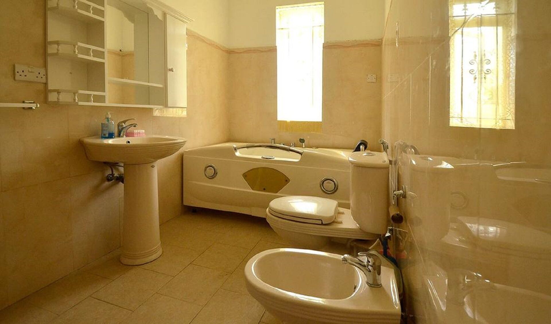 A bathroom with a pedestal sink, a bathtub, and a toilet.