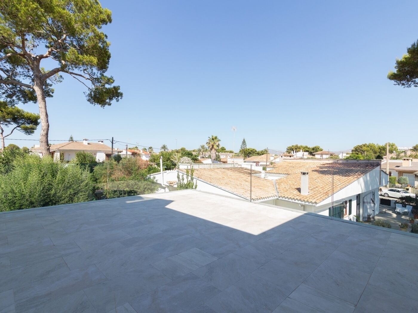Une terrasse sur le toit offrant une vue dégagée sur les bâtiments environnants et sur un arbre.