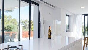 Een moderne keuken met een groot eiland, een wijnfles en een glas.