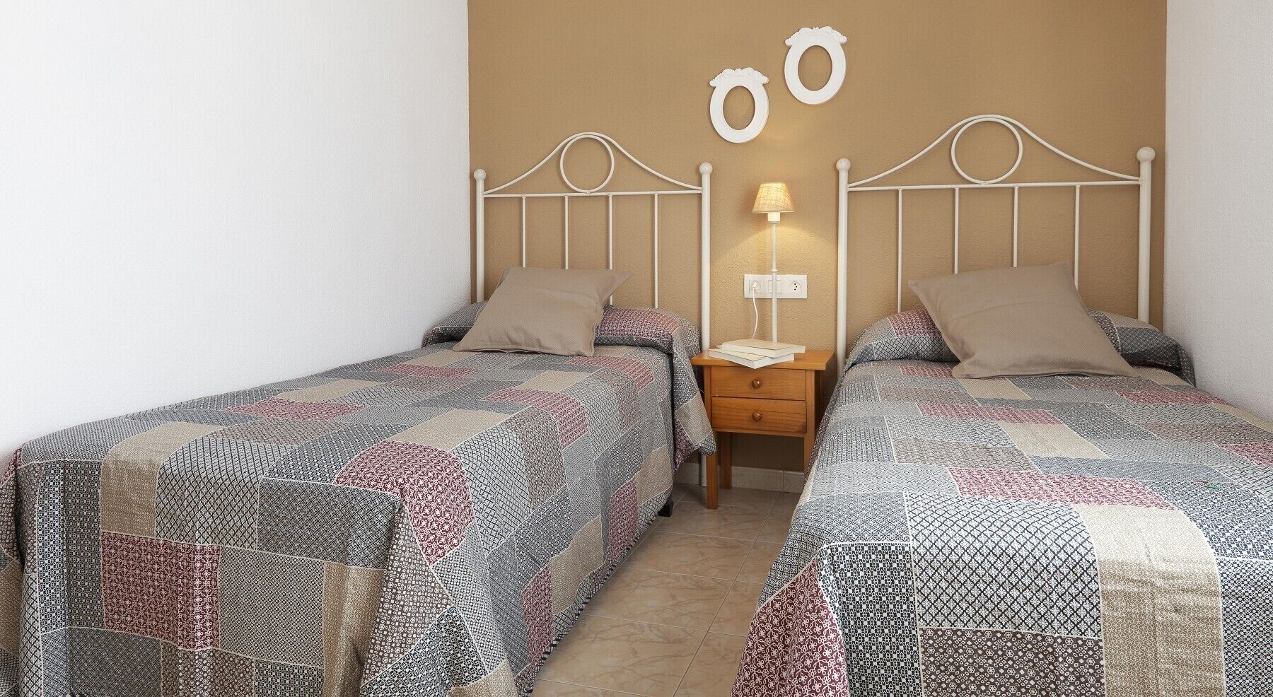 A double bed room with a headboard, bedside tables, and a lamp.