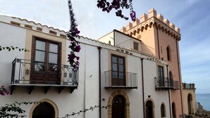 A traditional building with multiple balconies, arched doorways, and a tower-like structure.