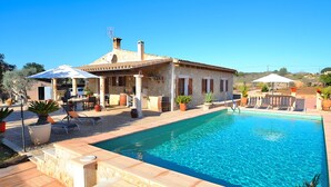A poolside area with a stone house, outdoor furniture, and potted plants. - Sa Rota 078 fantastic finca with private pool, garden, ping pong and fibre optics (Ariany)