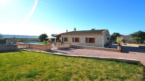 A stone house with a swimming pool, surrounded by a well-maintained lawn and a gravel driveway. - Sa Rota 078 fantastic finca with private pool, garden, ping pong and fibre optics (Ariany)