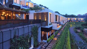 A modern hotel with multiple levels, outdoor terraces, and a well-maintained garden area. - The Sterling Villas (Pecatu)