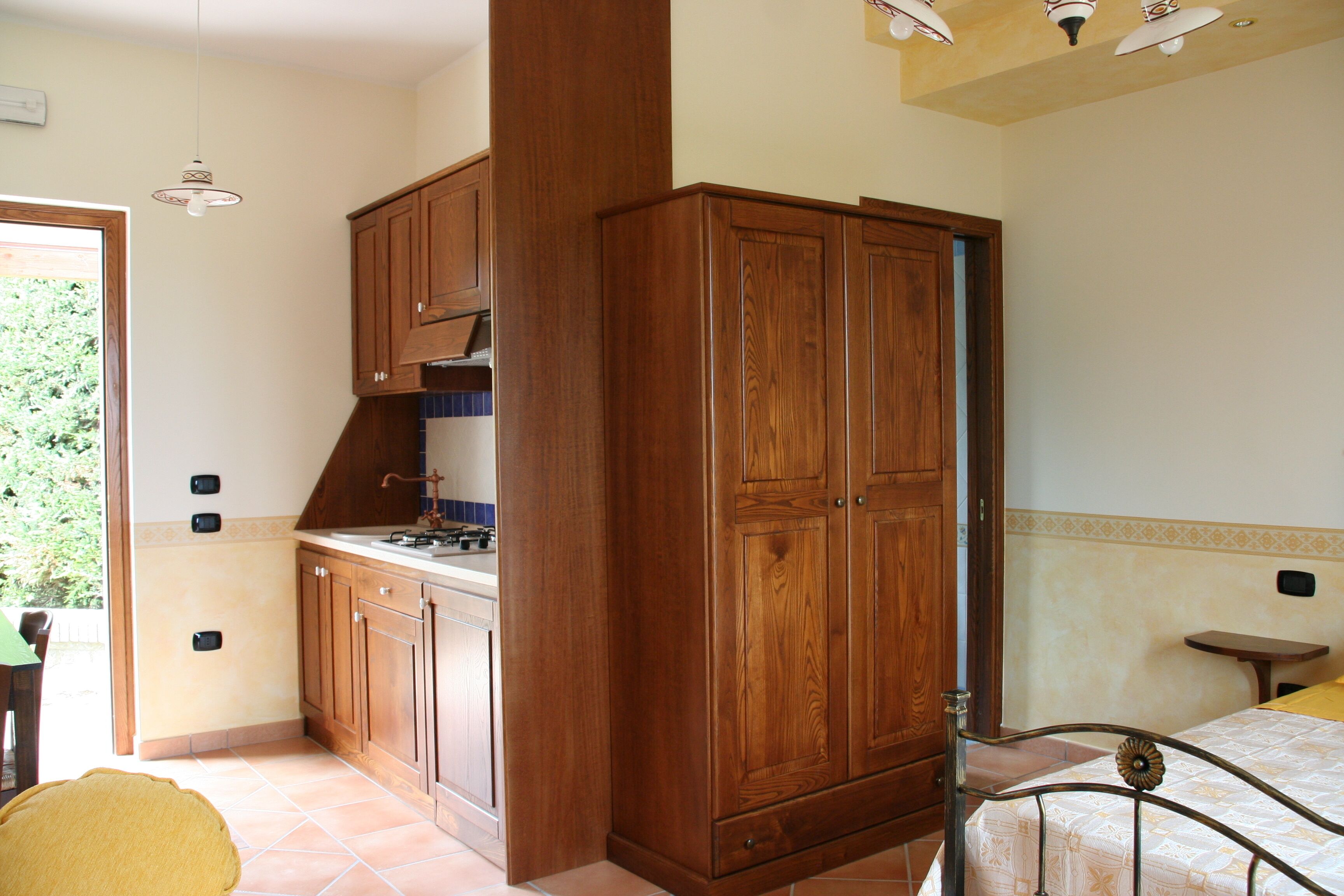 Una cocina pequeña con armarios de madera, una estufa y un lavamanos.