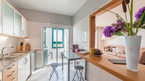Une cuisine moderne avec une table à manger en verre, un plan de travail en bois et un vase rempli de fleurs.