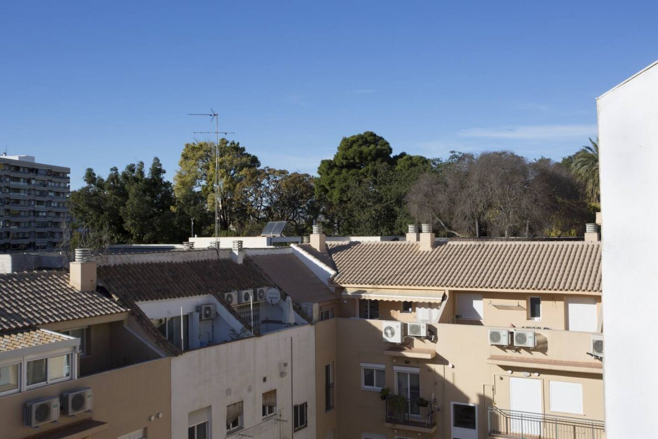 Un edificio residencial con varios balcones, unidades de aire acondicionado y una vista despejada del entorno.
