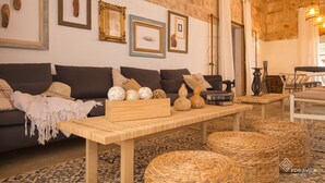 A cozy living room with a sofa, wooden coffee table, and woven ottomans. - Finca Son Grauet - Spectacular villa with pool in Llucmajor (LLucmajor)