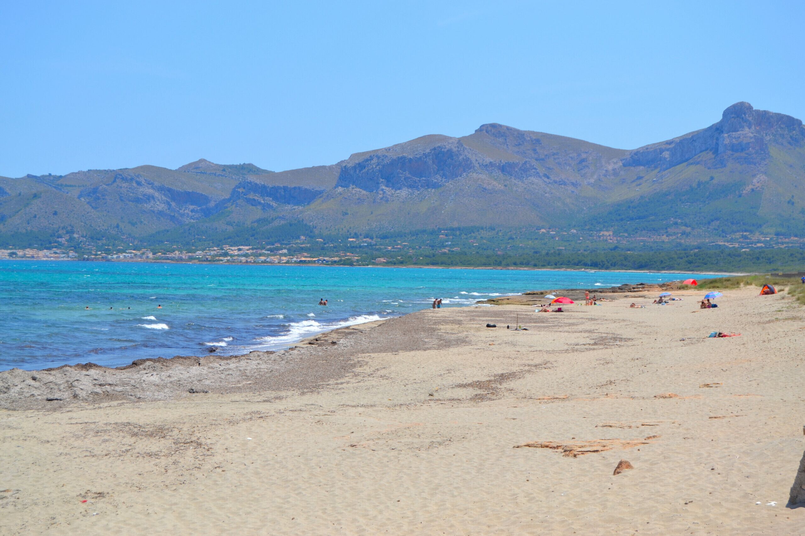 Ranta lähistöllä, aurinkotuoleja, rantapyyhkeitä