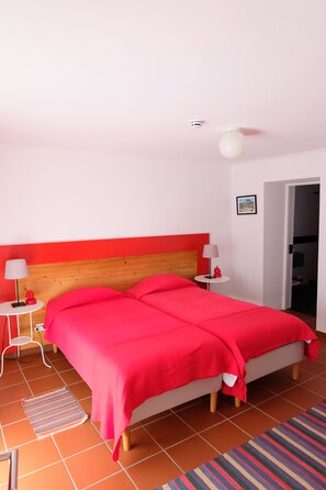 Ein Hotelzimmer mit Bett, Nachttisch, Lampe und Tür.