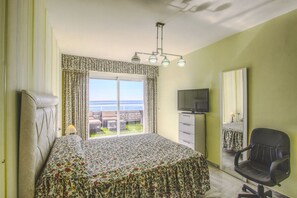 A bedroom with a bed, a TV, a chair, and a window with a view of the sea. - 1149 Stunning Duplex Penthouse with Panoramic Sea Views (Marbella)
