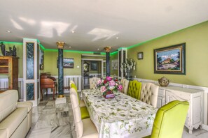 A dining room with a marble floor, green walls, and a table set for four. - 1149 Stunning Duplex Penthouse with Panoramic Sea Views (Marbella)