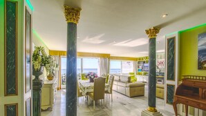 A spacious living area with a dining table, sofas, and a view of the sea. - 1149 Stunning Duplex Penthouse with Panoramic Sea Views (Marbella)