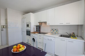 A compact kitchen with white cabinets, a built-in oven, a washing machine, and a sink. - 1149 Stunning Duplex Penthouse with Panoramic Sea Views (Marbella)