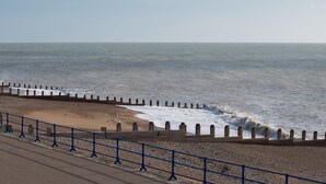 A beach with a wooden sea wall and a blue railing. - Silverdale Sunbeams, 4 bedroom spacious apartment close to seafront (Eastbourne)