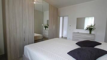 Une chambre à coucher avec un grand lit, une armoire, une commode et un miroir.