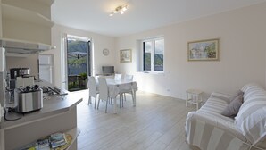 Une cuisine moderne et bien éclairée, avec un coin repas, un canapé et une vue sur l’extérieur.