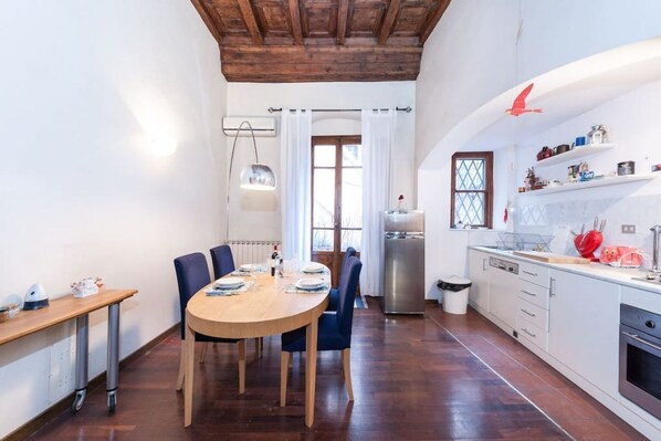 A modern kitchen with white cabinets, a wooden dining table, and chairs.