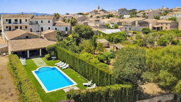 Un quartier résidentiel doté d’une piscine, de chaises longues et offrant une vue sur la ville.