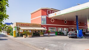 Eine Tankstelle La Trocha mit einem roten Gebäude, einer weißen Markise und einem blauen Schild.