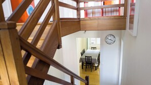 Eine Treppe führt zu einem Essbereich, an der Wand hängt eine Uhr.