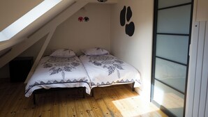 Ein Schlafzimmer mit zwei Betten, einem Oberlicht und einer Schiebetür.