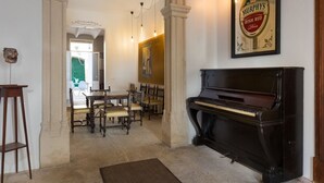 A dining area with a piano, a framed Murphy's Irish Red Beer sign, and a table with chairs.