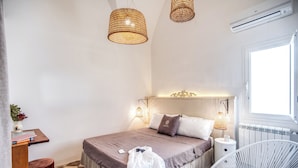Une chambre à coucher avec un lit, des tables de chevet, une chaise et une fenêtre.