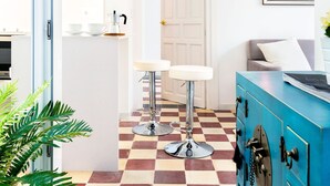 A modern kitchen with a checkered floor, a blue cabinet, and a white countertop. - Genteel Home Galera Terrace II (Seville)
