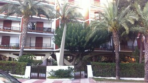 A multi-story building with balconies, palm trees, and a gated entrance. - See view, 500m from the beach,Aircon,WIFI,terrace (Roquetas de Mar)