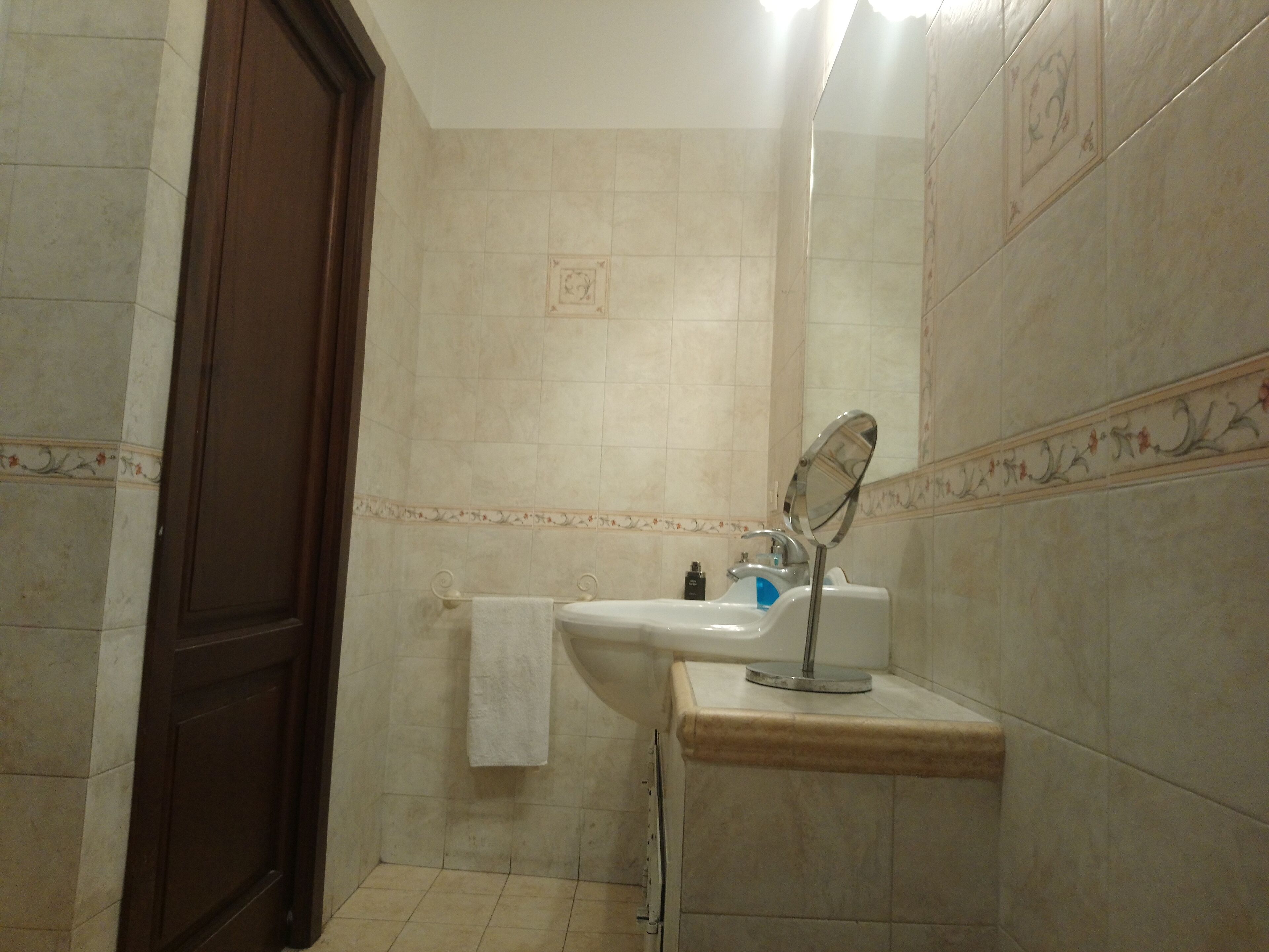 A bathroom with a sink, mirror, and towel rack.