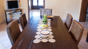 A dining table with a woven chair arrangement, a glass of juice, and a decorative bowl. - Villa Rose - Marina Di Mancaversa (Marina di mancaversa)