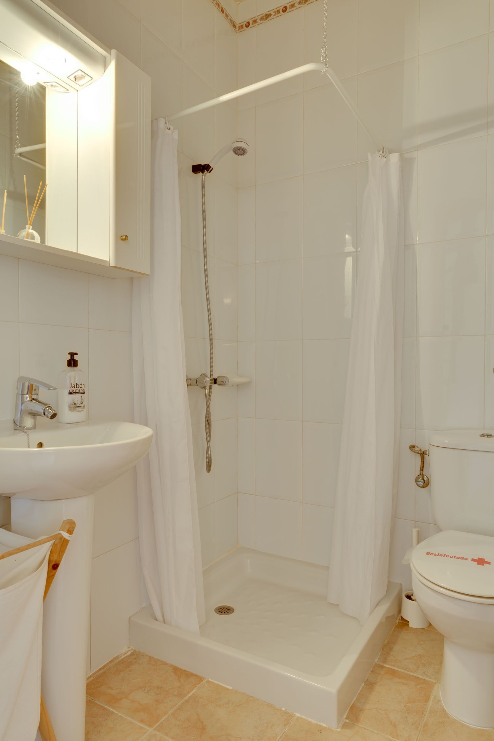 A bathroom with a shower, sink, and toilet.