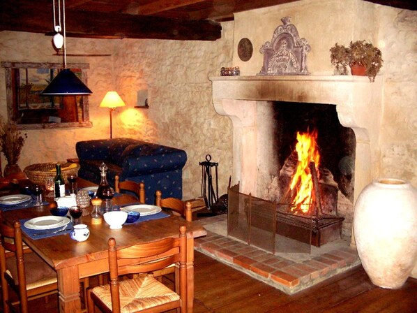 Un comedor acogedor con chimenea, muebles de madera y una mesa lista para una comida.