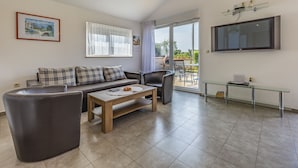 A modern living room with a sofa, armchairs, a coffee table, and a TV. - Villa Sandra 4+2 with pool, garden & terrace with barbecue & free Wi-Fi (Ližnjan)