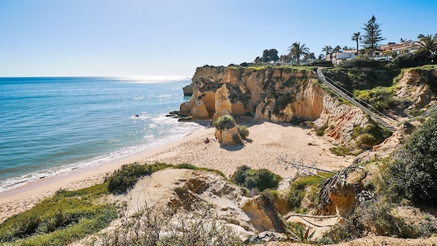 A coastal landscape with a sandy beach, rocky cliffs, and a clear blue sky. - APARTMENT TANSY DIRECTLY BY THE SEA WITH A DREAM SEA VIEW AND POOL (Armacao de Pera)