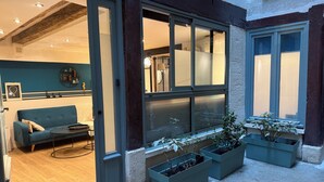 Ein modernes Interieur mit einer Couch, einem Esstisch und einem großen Fenster mit Blick nach draußen.