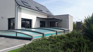 A modern house with a swimming pool and a covered patio area.