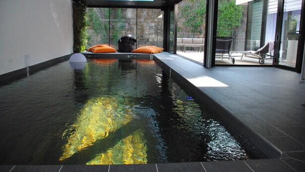 A modern indoor swimming pool with a view of a garden and a patio area. - Villa Grand Standing 170m2 :4*, Pool & Jacuzzi PRIVATE: 5 Mn from the beaches (Perros-Guirec)
