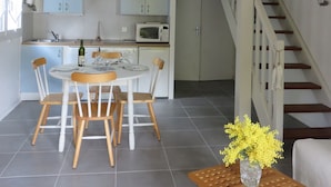 Une maison à deux étages comprenant un coin repas, une cuisine et un escalier.